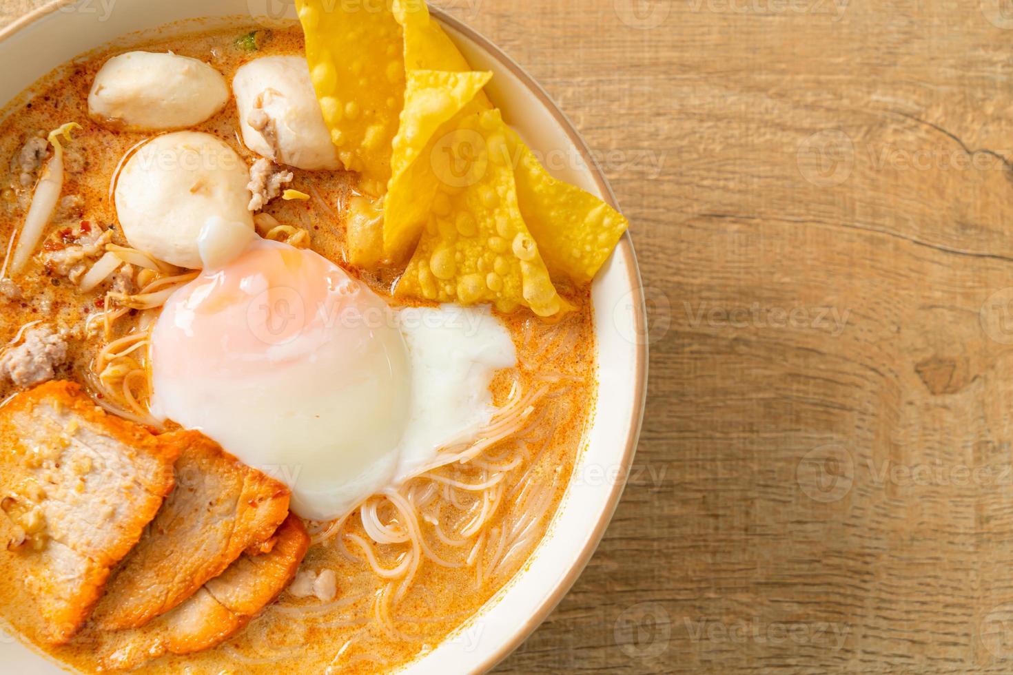 fideos de arroz con albóndigas, cerdo asado y huevo en sopa picante foto