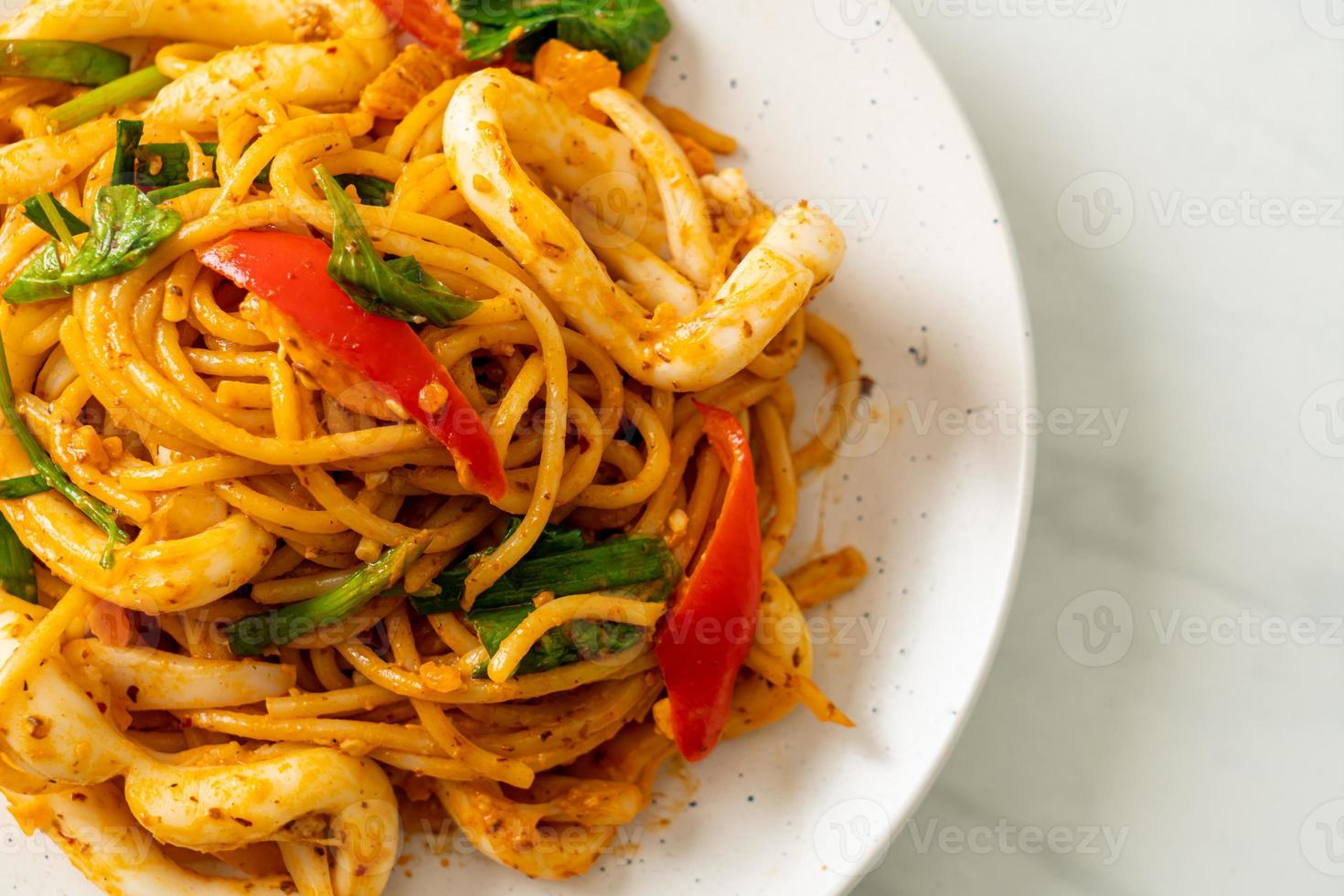 Stir-fried spaghetti with salted egg and squid - fusion food style photo