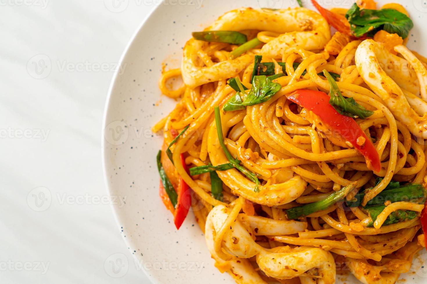 espaguetis salteados con huevo salado y calamares - estilo de comida fusión foto