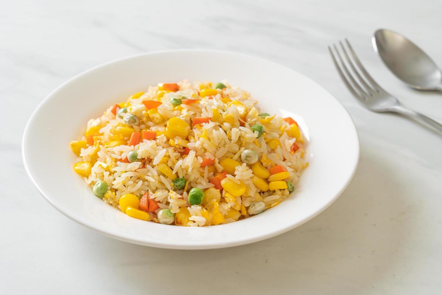 Homemade fried rice with mixed vegetables of carrot, green bean peas, corn, and egg photo