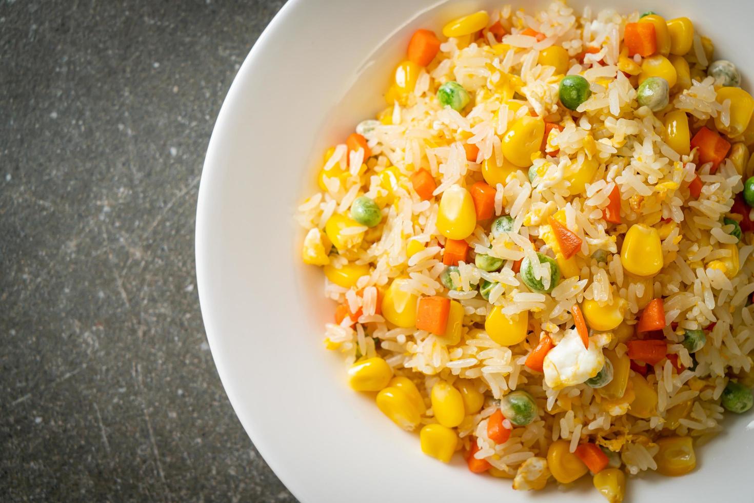 Homemade fried rice with mixed vegetables of carrot, green bean peas, corn, and egg photo