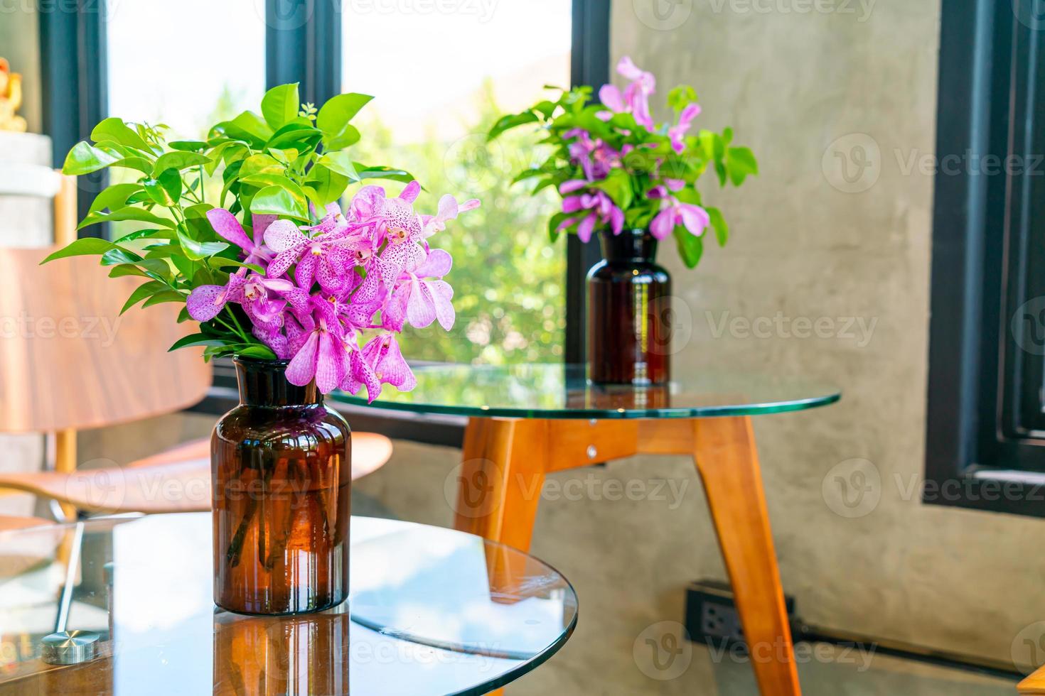Orchid flowers in vase decoration on table in coffee shop cafe restaurant photo