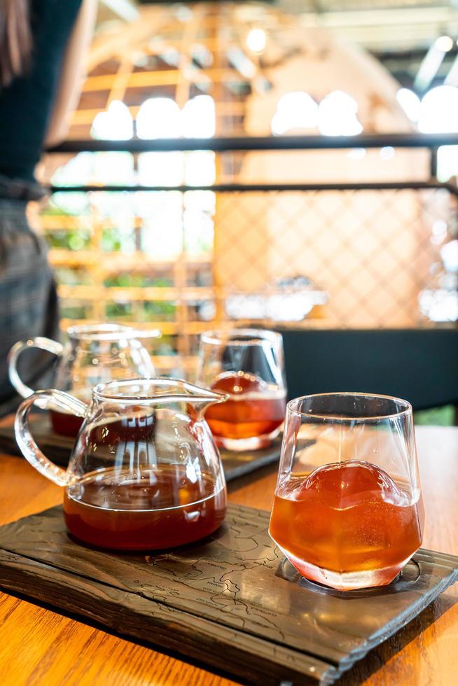 Tarro de café negro por goteo frío con vidrio y hielo en la cafetería, cafetería y restaurante foto