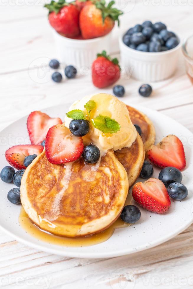 Souffle pancake with blueberries, strawberries, honey, and vanilla ice-cream photo