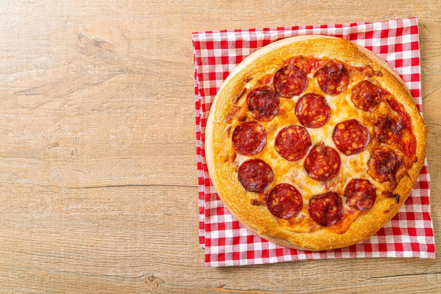 Pizza de pepperoni en bandeja de madera - estilo de comida italiana foto