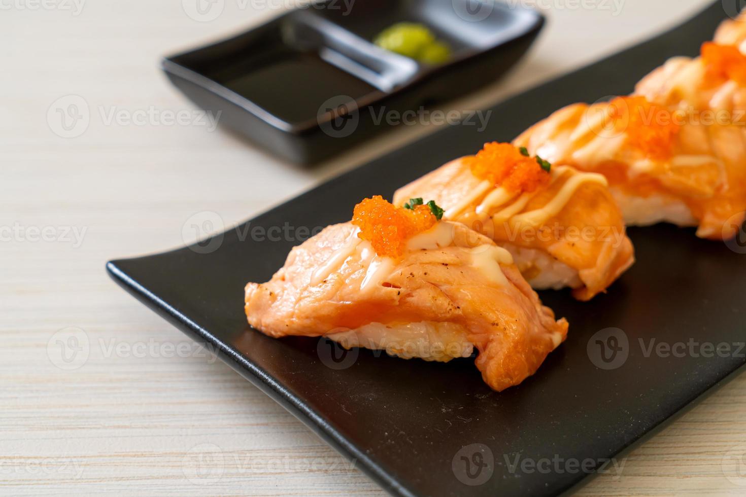 Grilled salmon sushi on black plate - Japanese food style photo