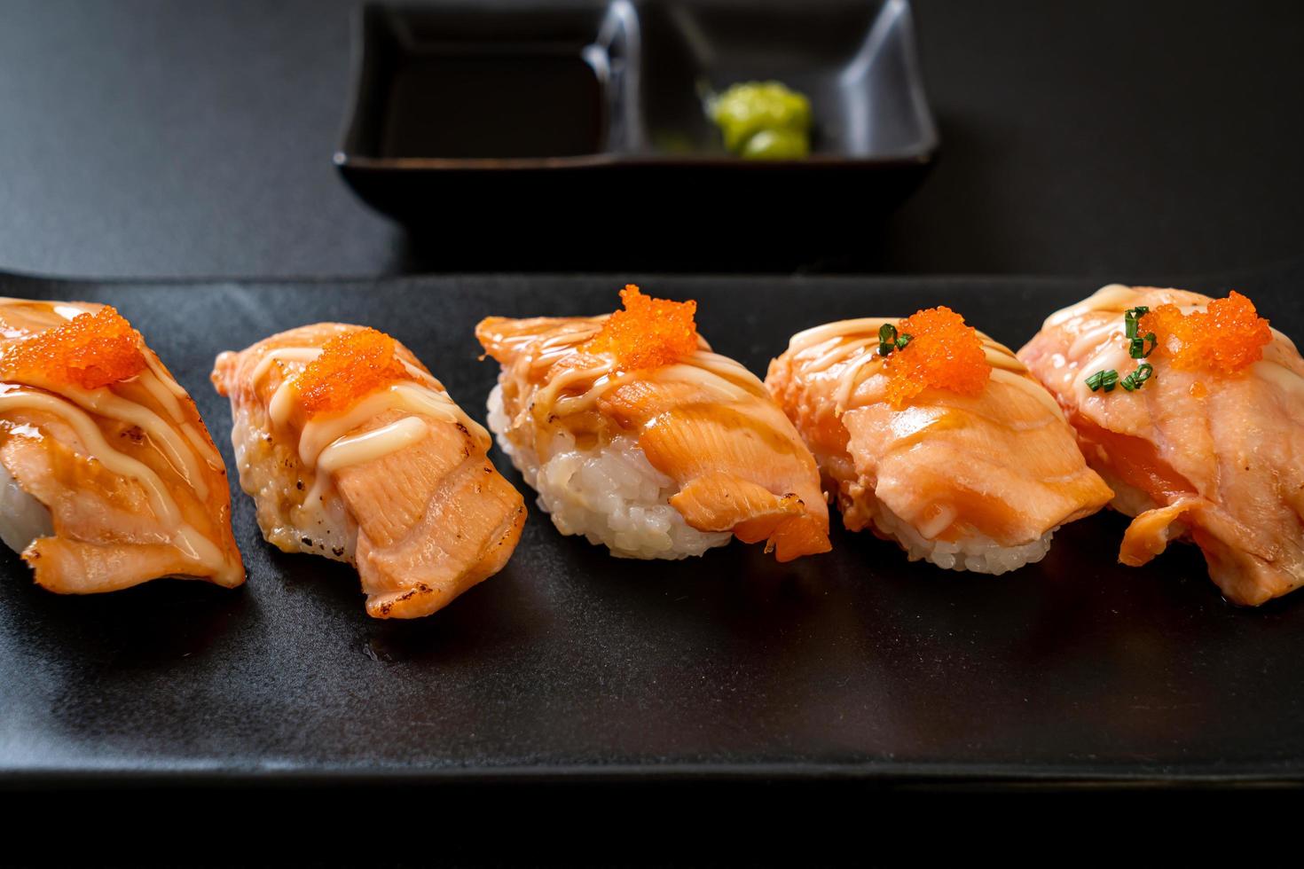 Sushi de salmón a la parrilla en placa negra - estilo de comida japonesa foto