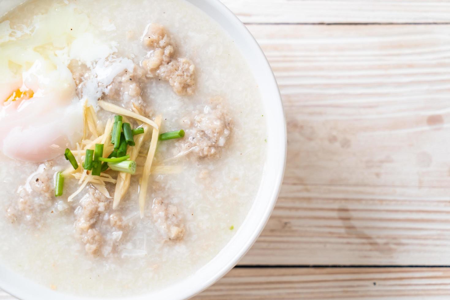 Congee con carne de cerdo picada en un tazón - estilo de desayuno asiático foto