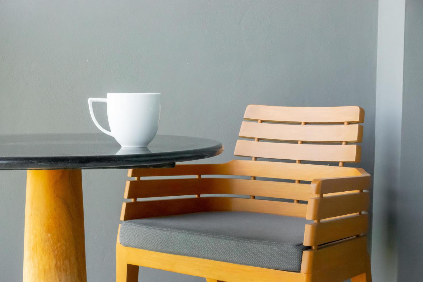 Coffee cup on table with empty chair photo