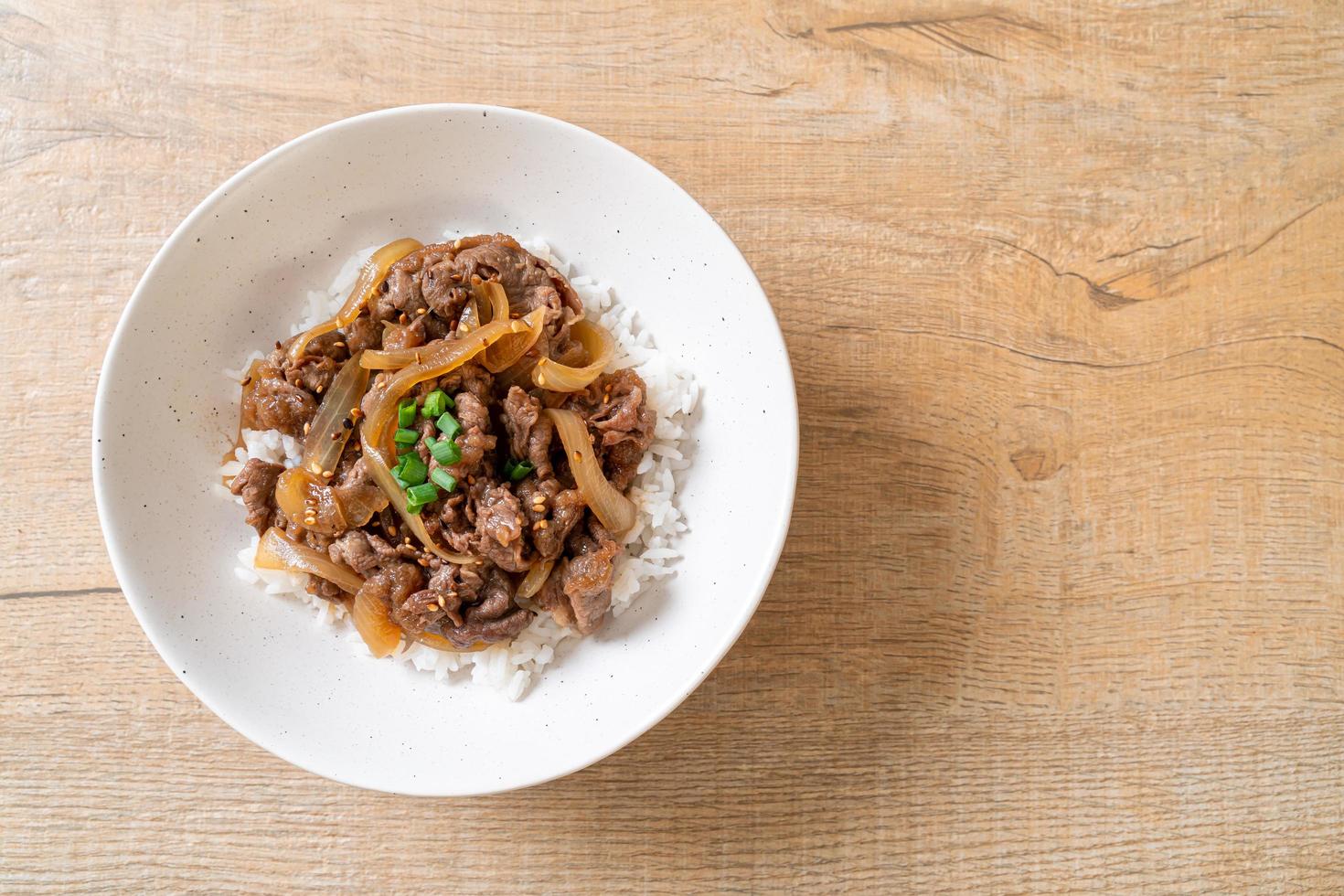 carne de res en rodajas sobre arroz cubierto o gyudon - estilo de comida japonesa foto