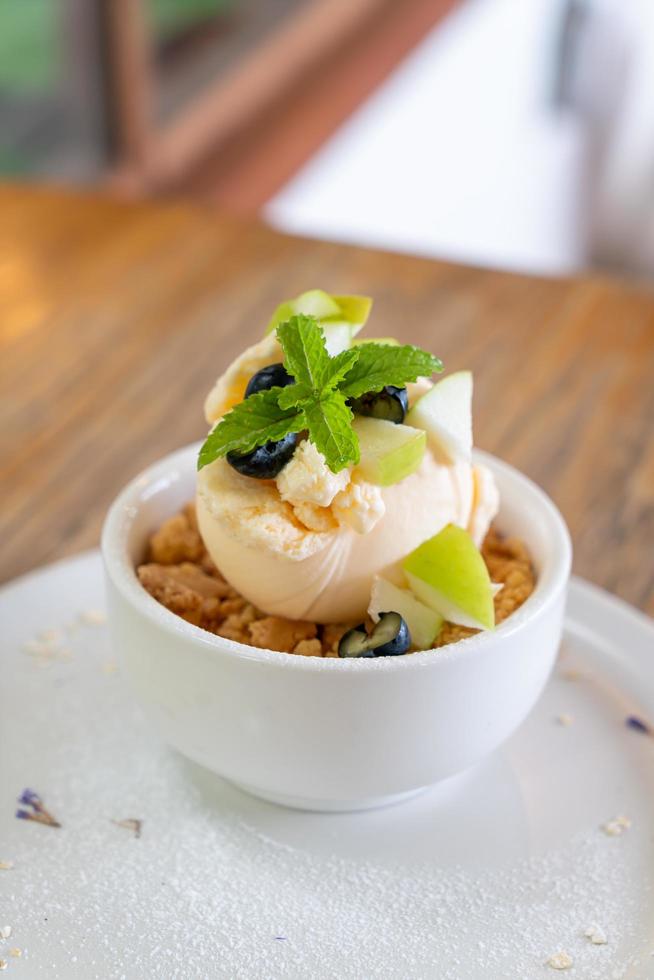 Helado de vainilla con manzana fresca y crumble de manzana en cafetería y restaurante foto