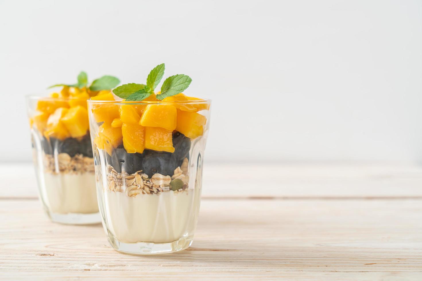 Homemade fresh mango and fresh blueberry with yogurt and granola - healthy food style photo