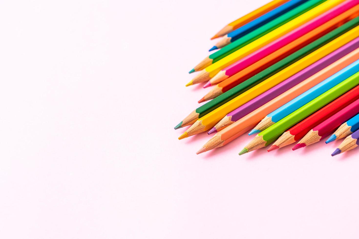 lápices de colores sobre fondo rosa con espacio de copia foto