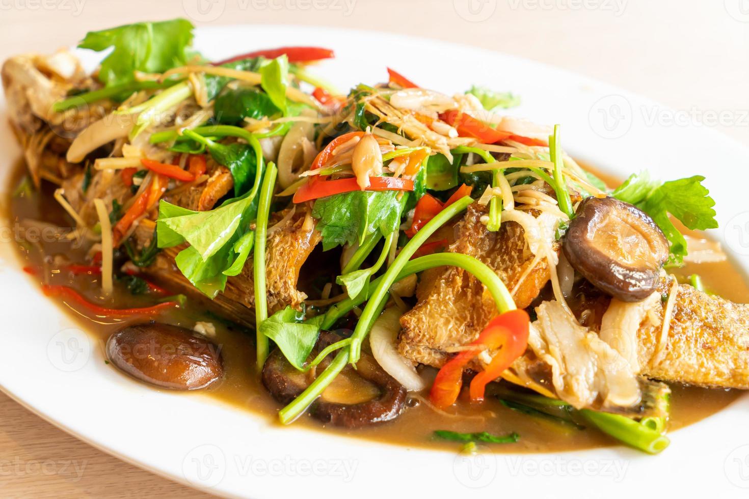 Deep-fried sea bass fish with sweet sauce and trimmings - Asian food style photo