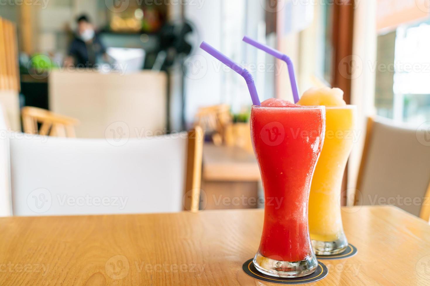 Batido de naranja y vaso de batido de sandía en café restaurante foto