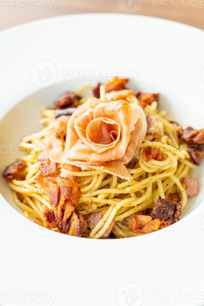 espaguetis con chile, aceite de oliva y tocino prosciutto - estilo de comida italiana foto