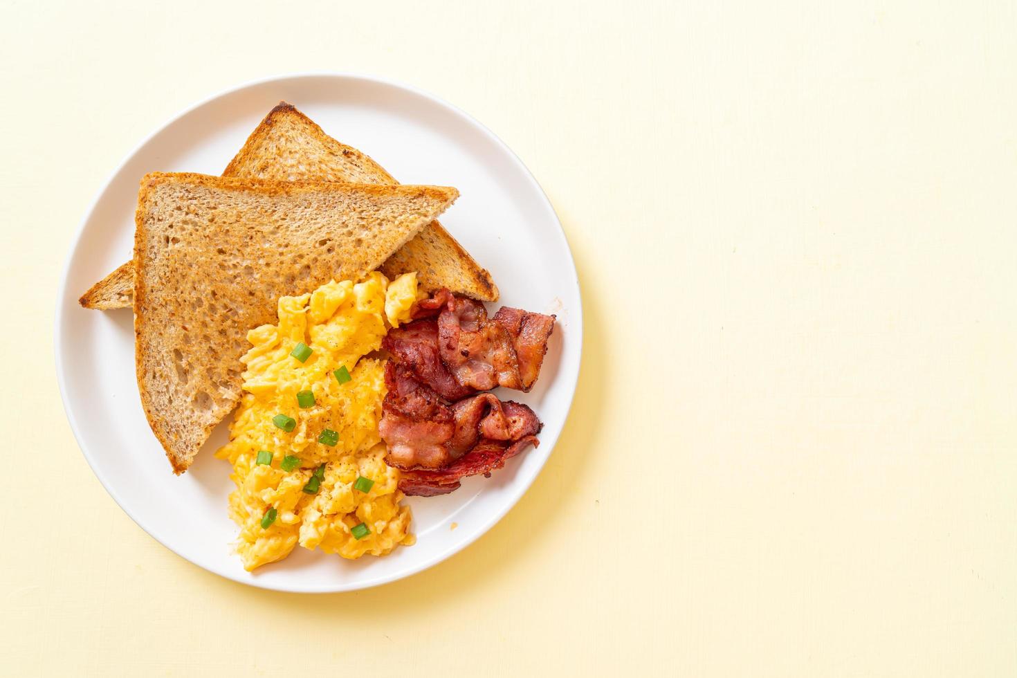 Scrambled egg with bread toasted and bacon for breakfast photo