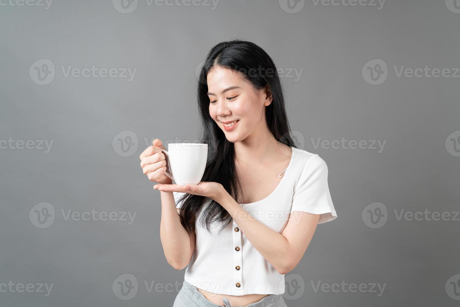 Young Asian woman with happy face and hand holding coffee cup photo