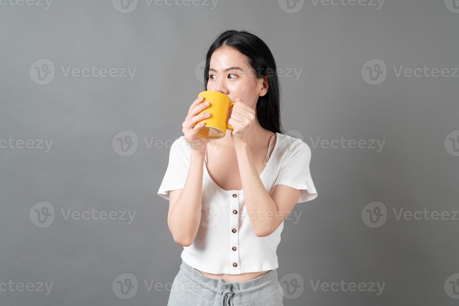 joven, mujer asiática, con, cara feliz, y, mano, tenencia, taza de café foto