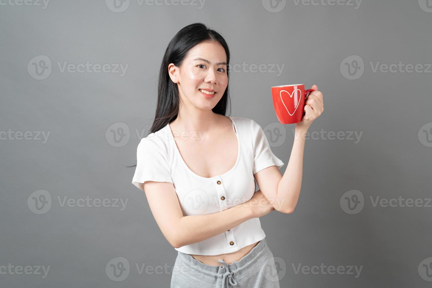 joven, mujer asiática, con, cara feliz, y, mano, tenencia, taza de café foto