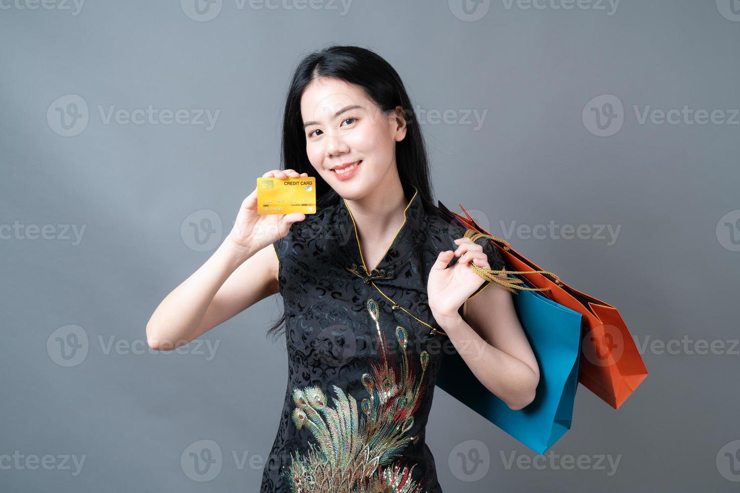 Asian woman wear Chinese traditional dress with shopping bag and credit card photo