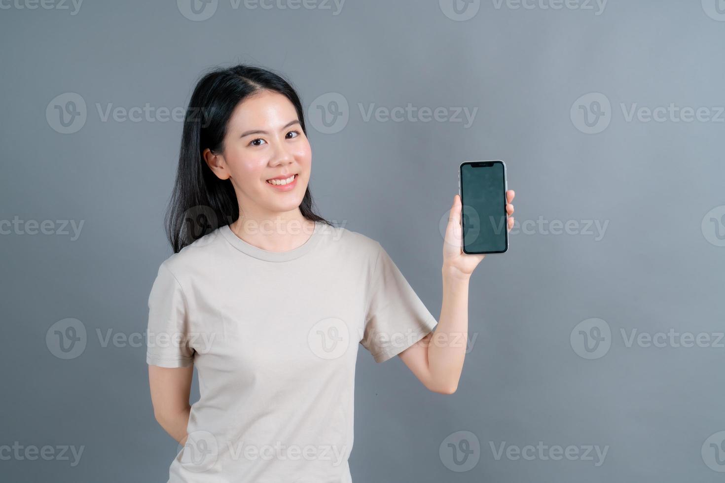 Asian woman using mobile phone applications, enjoying communicating distantly online in social network or shopping photo