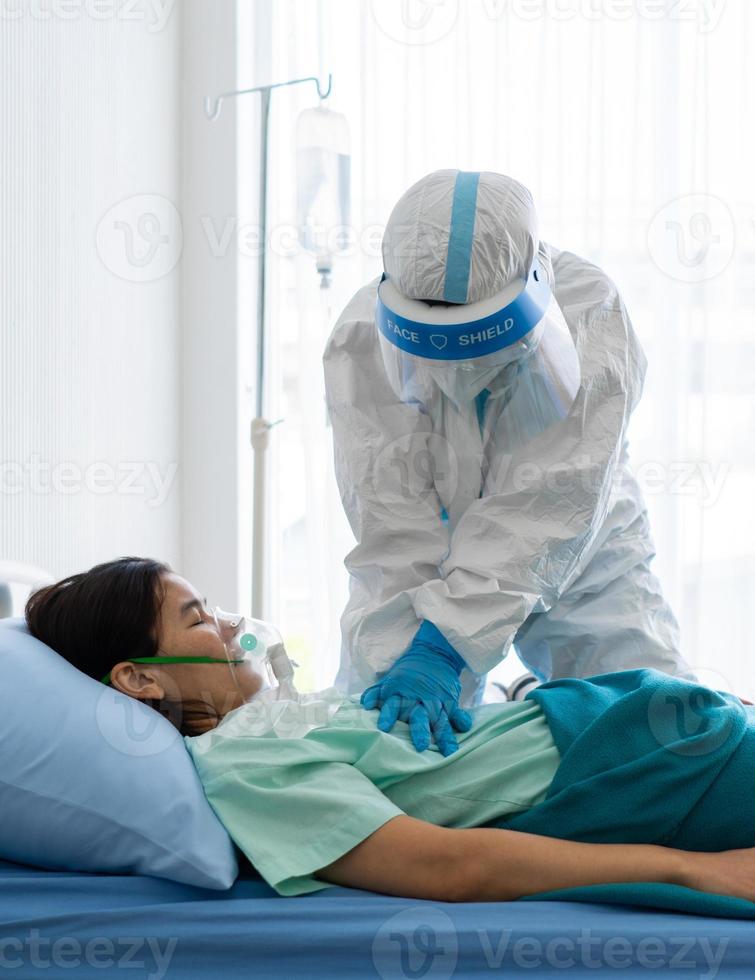 Doctor in personal protective equipment or ppe perform chest compression or cpr for patient with covid-19 or coronavirus infection who has sudden collapse in isolation unit photo