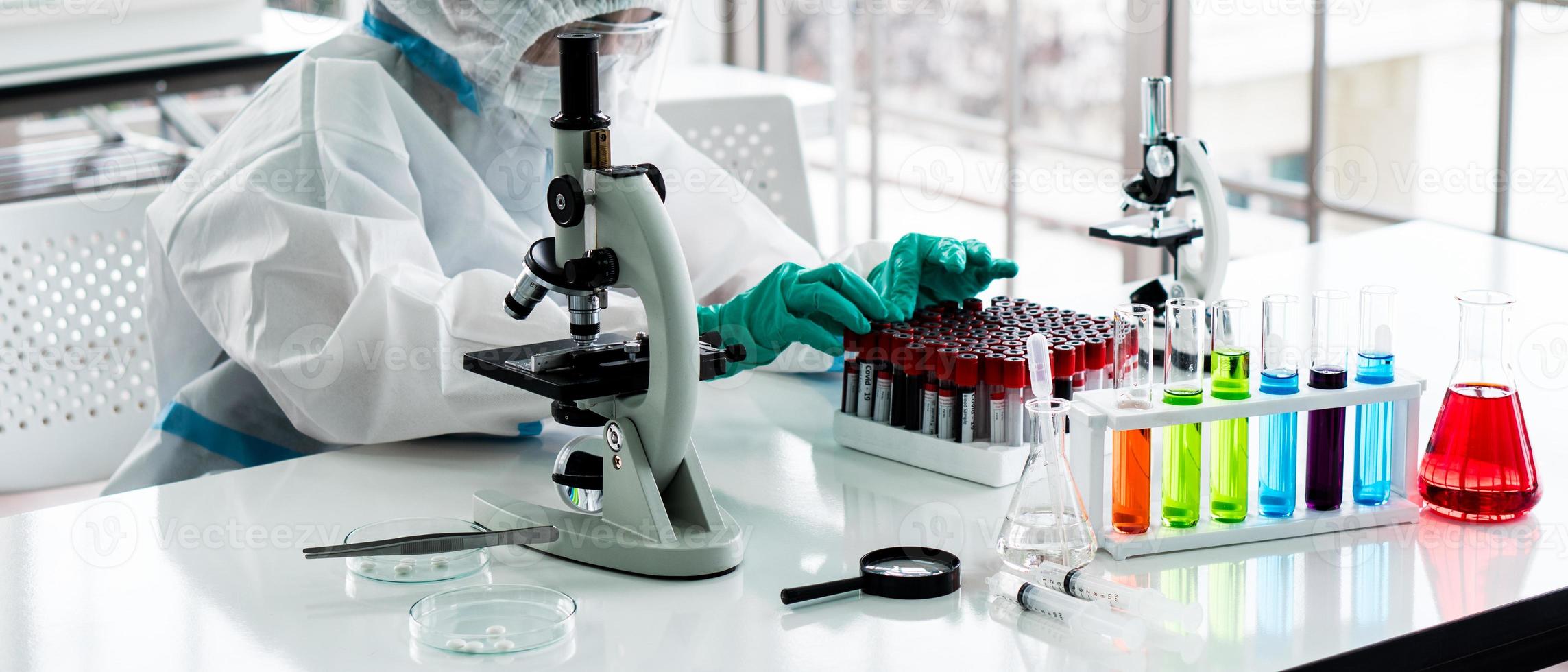 Banner picture of scientist in personal protective equipment or ppe doing research and experiment to find drugs to treat covid-19 or coronavirus infection in the lab photo