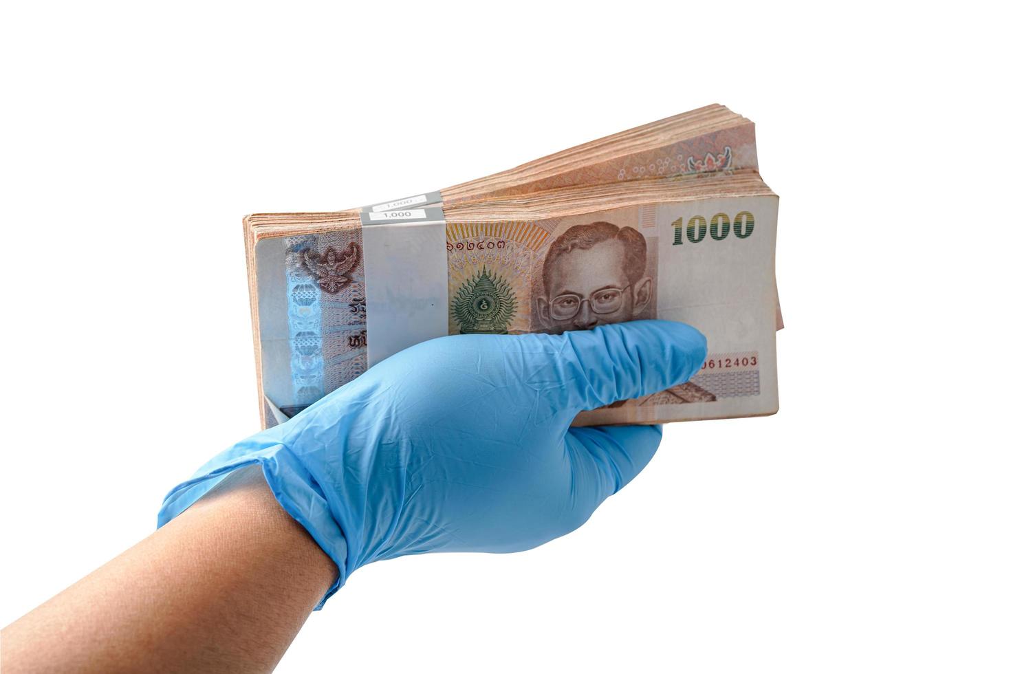 Hand with globe holding Thai baht banknotes isolated on white background with clipping path. photo
