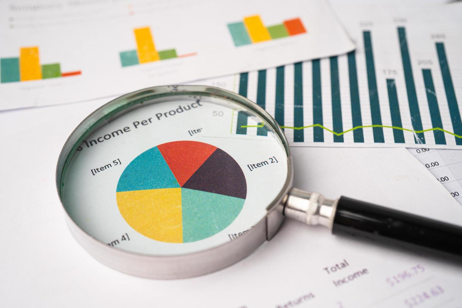 Magnifying glass on charts graphs paper. Financial development, Banking Account, Statistics, Investment Analytic research data economy, Stock exchange trading, Business office company meeting concept. photo