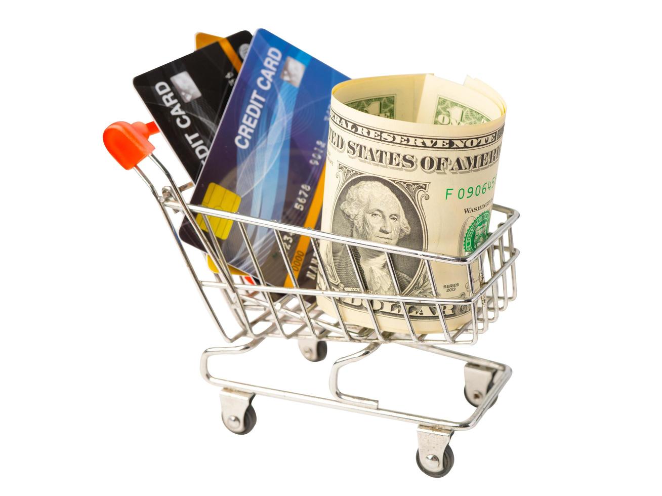 tarjeta de crédito y billetes de dólar estadounidense en carrito de compras aislado sobre fondo blanco, concepto de finanzas. foto