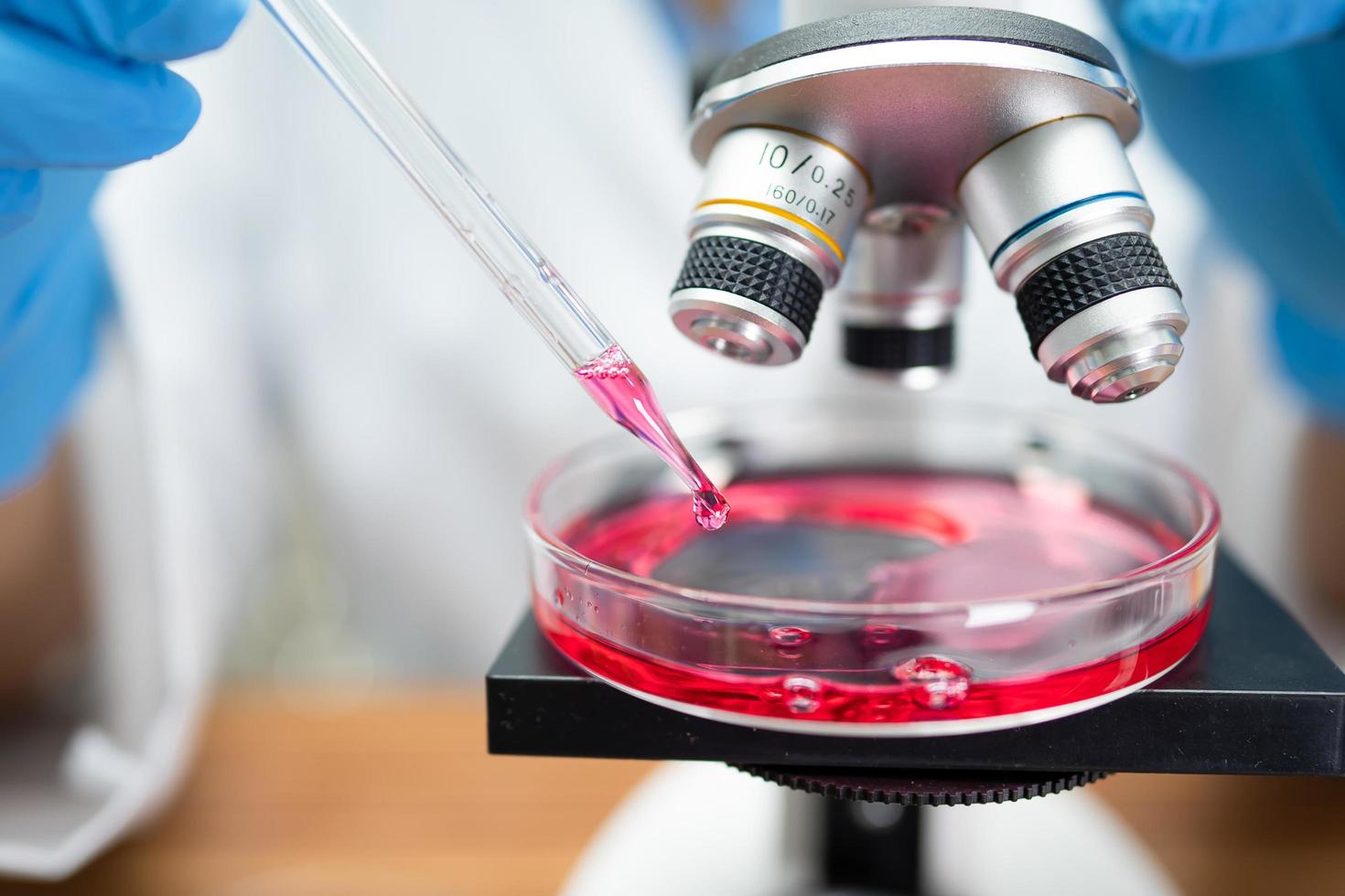 Asian scientist biochemist or microbiologist working research with a microscope in laboratory. For protect outbreak Coronavirus Covid19, bacteria and germs. photo