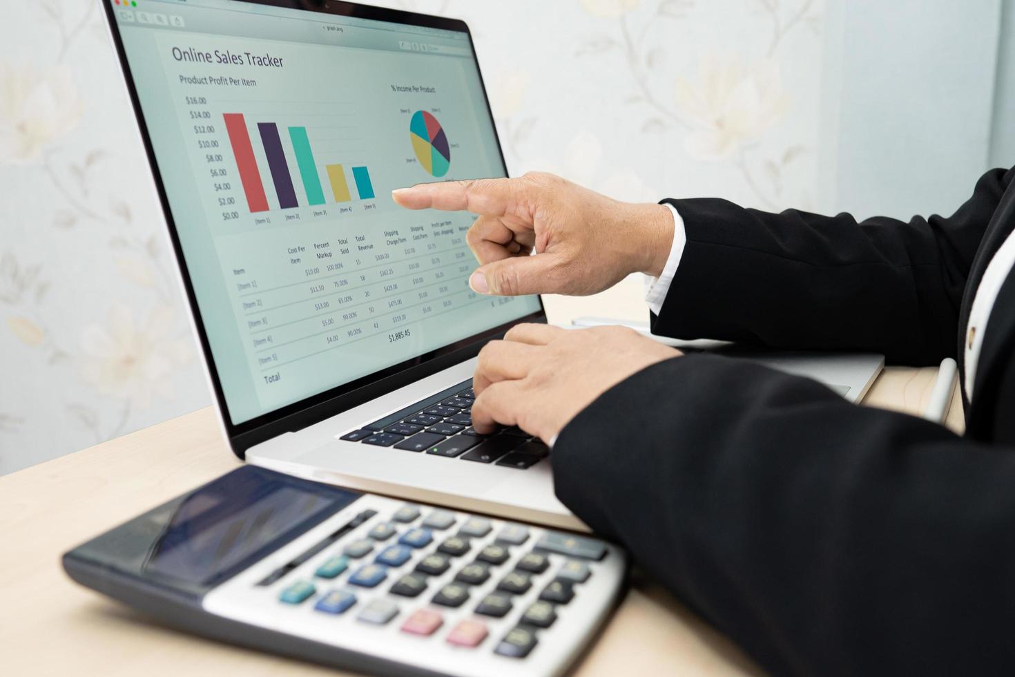 Asian accountant working and analyzing financial reports project accounting with chart graph and calculator in modern office, finance and business concept. photo