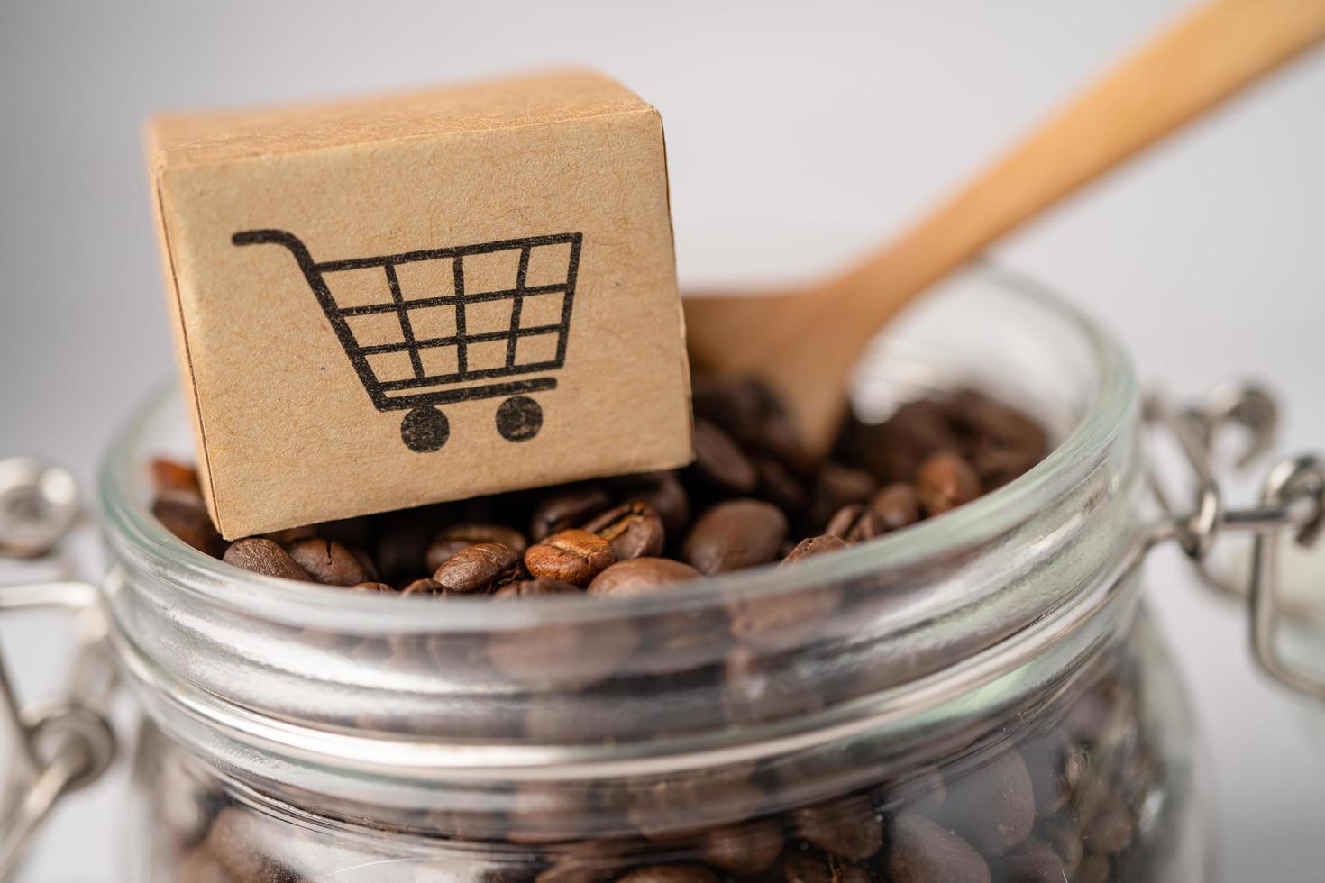 caja con el símbolo del logotipo del carrito de compras en granos de café, importación, exportación, compras en línea o servicio de entrega de comercio electrónico, envío de productos de tienda, comercio, concepto de proveedor. foto