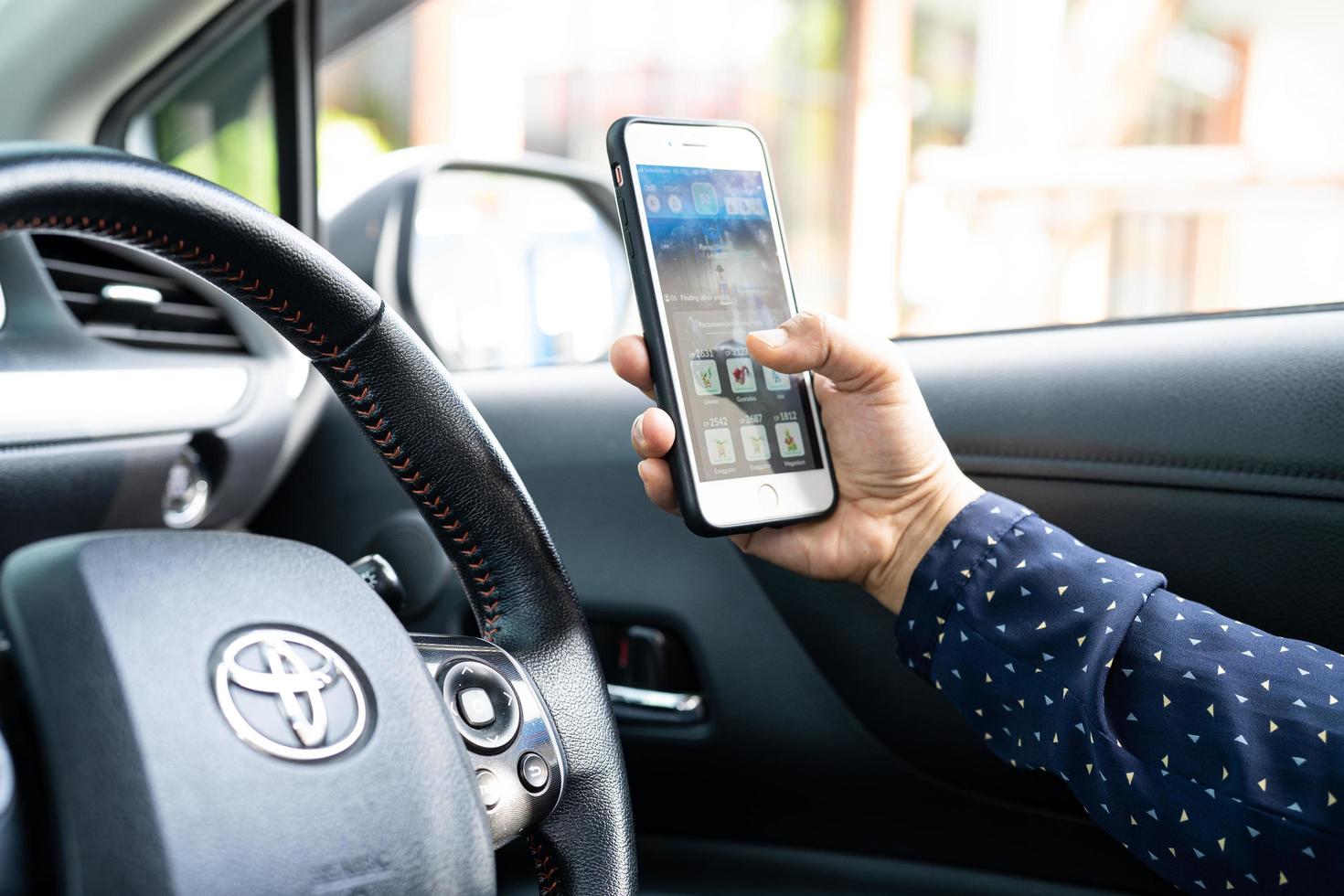 Bangkok, Thailand, July 1, 2020 Holding iPhone in toyota sienta car to communication with family and friends. photo