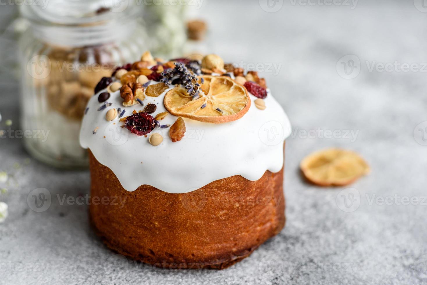 Pasteles festivos con glaseado blanco, nueces y pasas con huevos de pascua en la mesa festiva foto