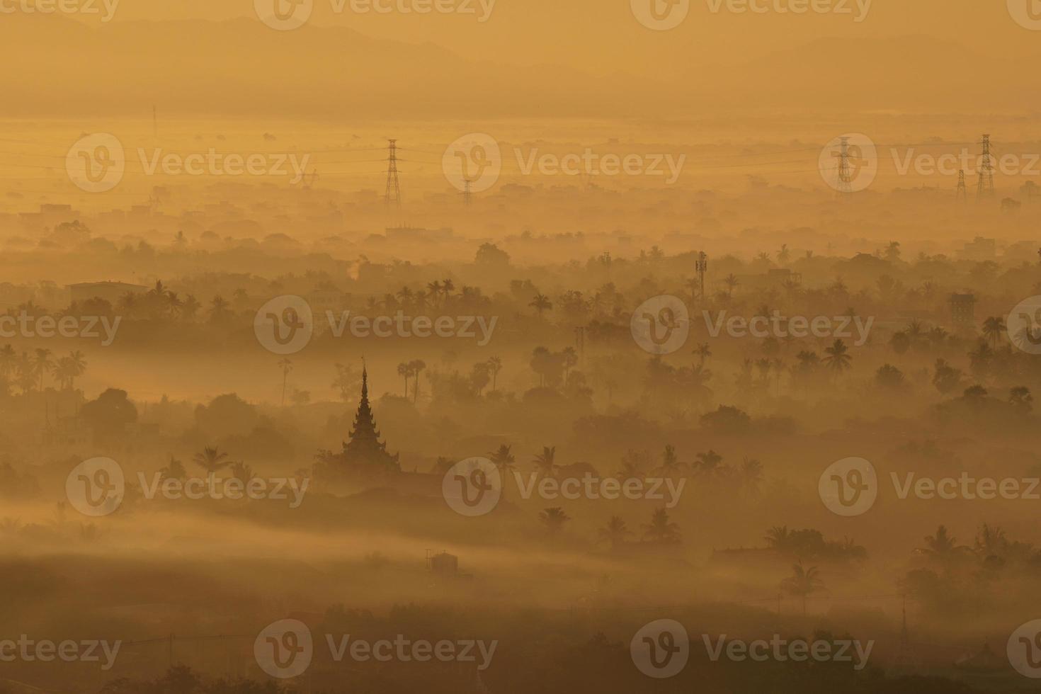 Top view of mandalay city covered with mist from mandalay hill at sunrise photo