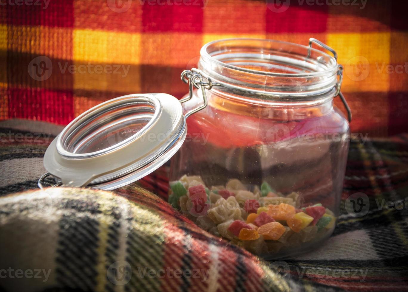 Colorful sugared fruit candies in a glass jar photo