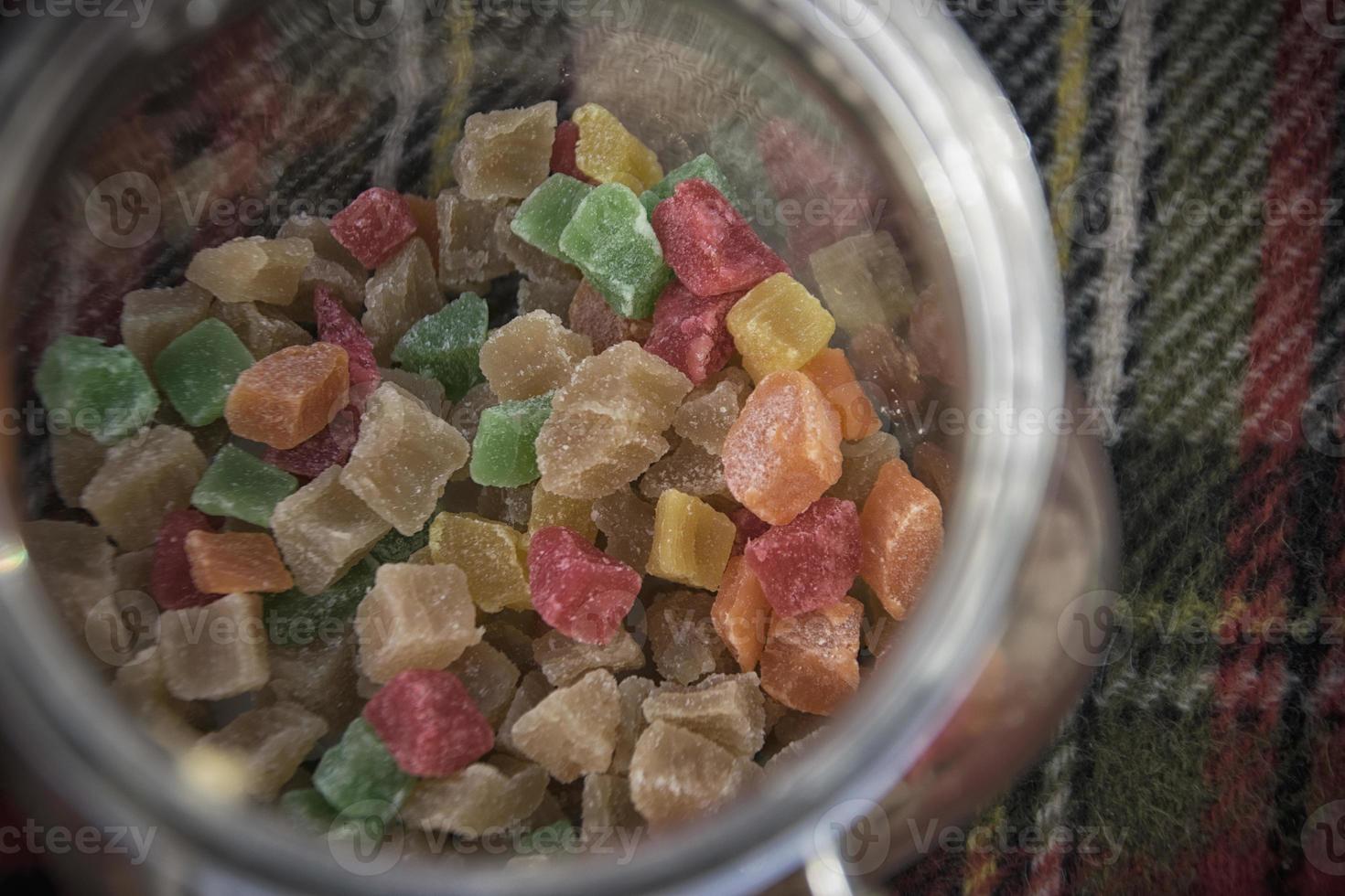 Colorful sugared fruit candies in a glass jar photo