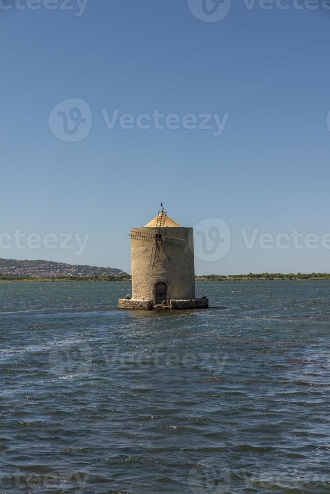 antiguo molino de viento en medio del mar en orbetello foto