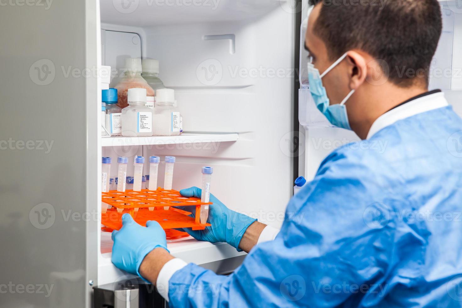 joven científico y congelador de laboratorio foto