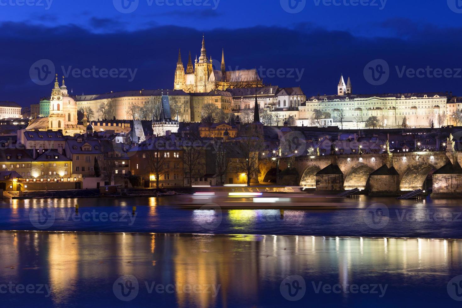 Noche de Navidad nevada colorida ciudad menor de Praga con el castillo gótico y el puente de Carlos, República Checa foto