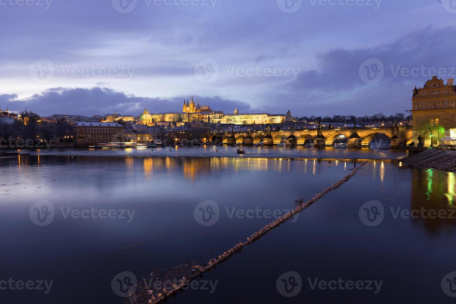 Noche de Navidad nevada colorida ciudad menor de Praga con el castillo gótico y el puente de Carlos, República Checa foto