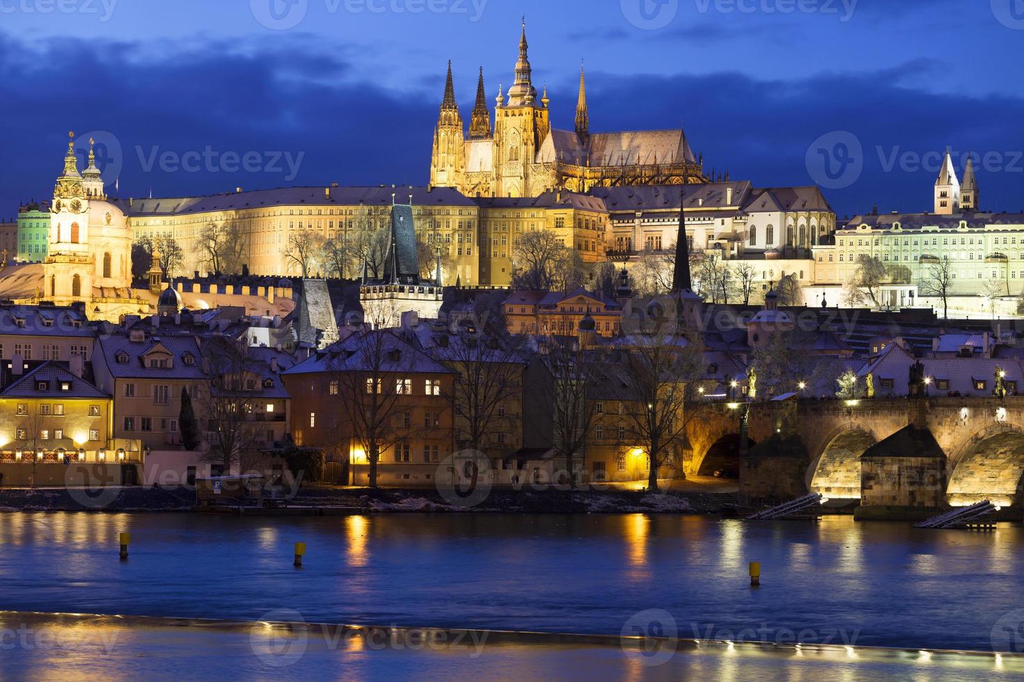 Noche de Navidad nevada colorida ciudad menor de Praga con el castillo gótico y el puente de Carlos, República Checa foto