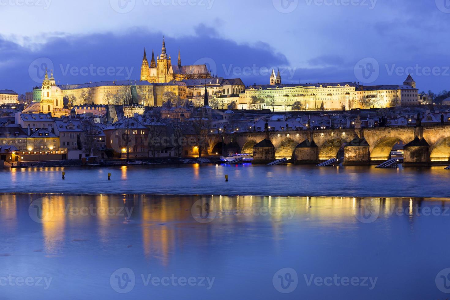 Night colorful snowy Christmas Prague Lesser Town with gothic Castle and Charles Bridge, Czech republic photo