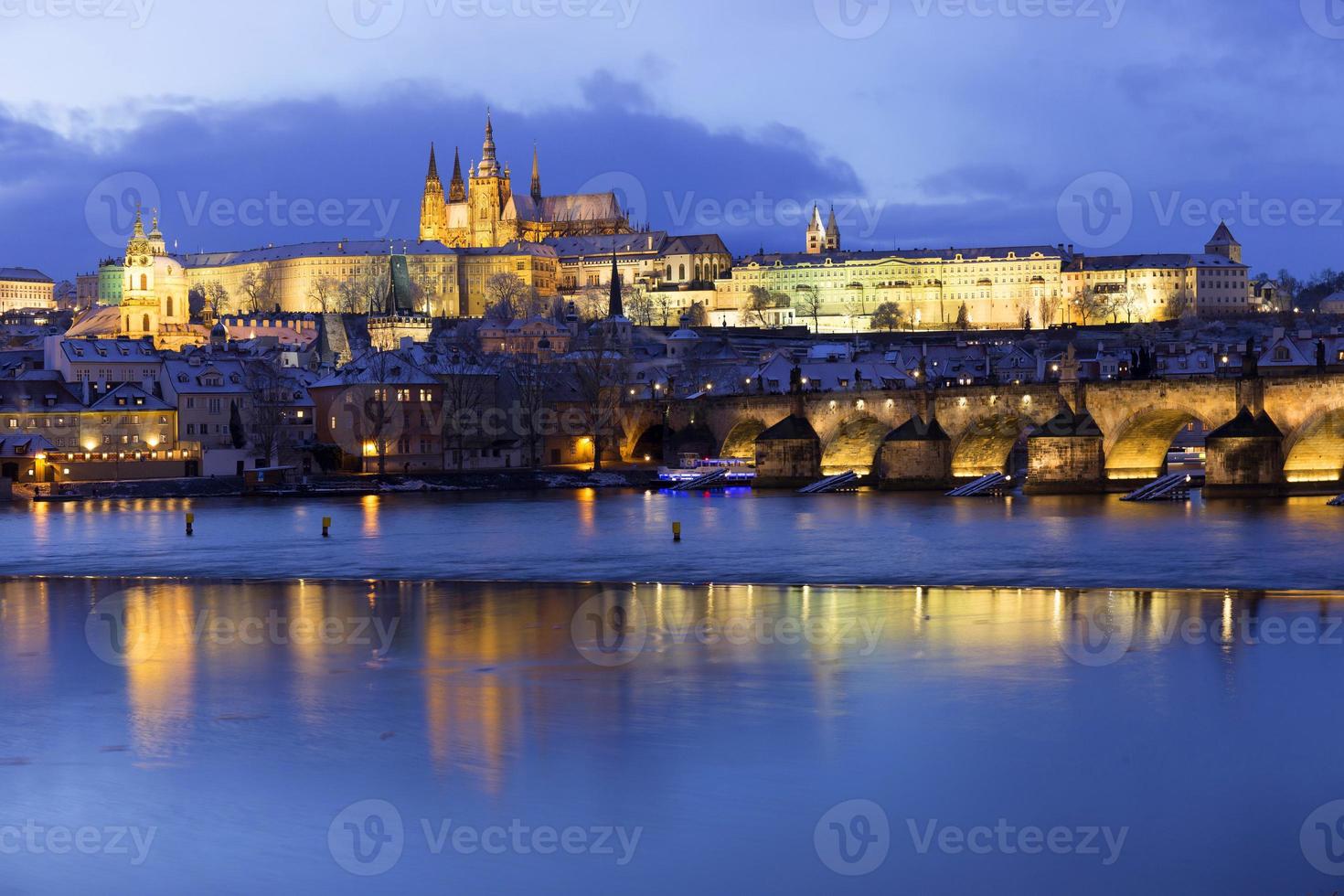 Noche de Navidad nevada colorida ciudad menor de Praga con el castillo gótico y el puente de Carlos, República Checa foto