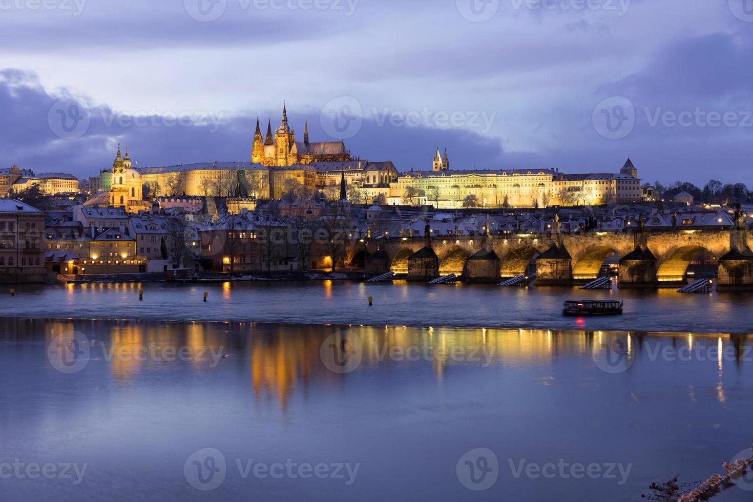 Noche de Navidad nevada colorida ciudad menor de Praga con el castillo gótico y el puente de Carlos, República Checa foto