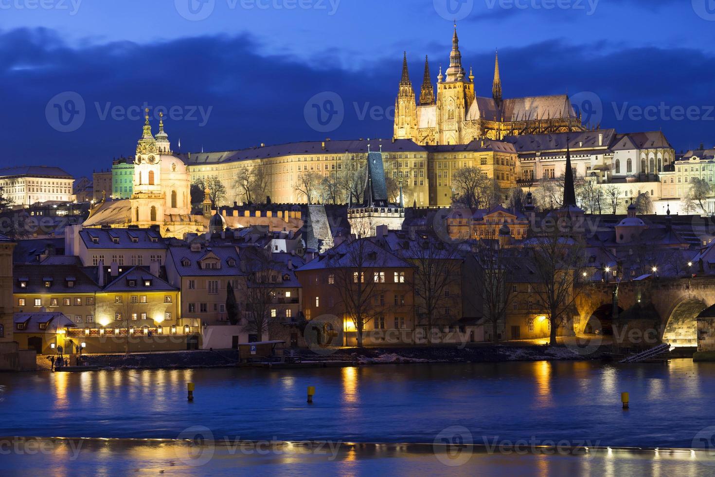 Noche de Navidad nevada colorida ciudad menor de Praga con el castillo gótico y el puente de Carlos, República Checa foto