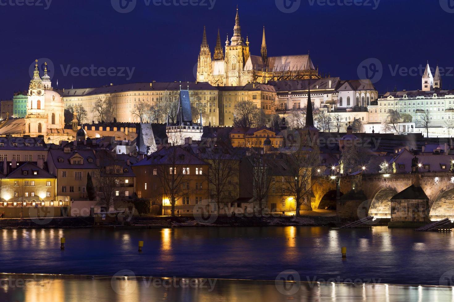 Noche de Navidad nevada colorida ciudad menor de Praga con el castillo gótico y el puente de Carlos, República Checa foto