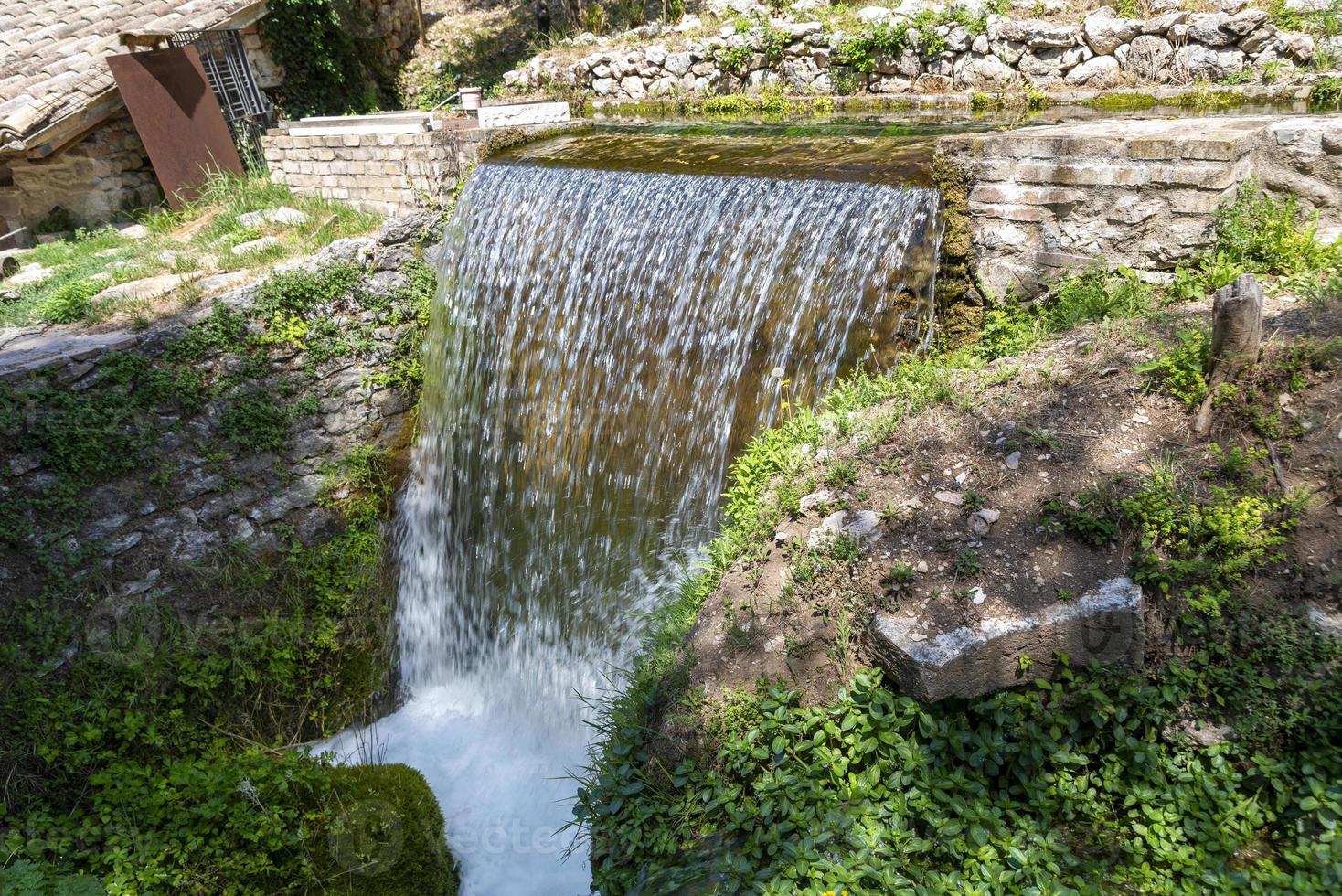 Small stream of water that forms a waterfall photo